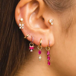 Detail of S925 silver butterfly and pink gem tassel earrings set on a model ear