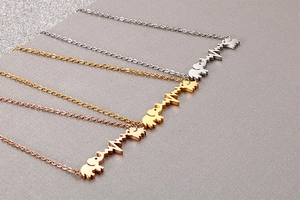 Detailansicht der Elefanten- und Herzschlag-Anhänger in Silber, Gold und Roségold
