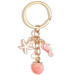 Golden starfish and seahorse shell keychain with pink enamel and pearl accents