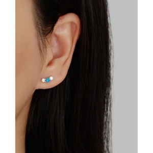 Detailed close-up of a s925 silver curved earring featuring a blue opal and zircons
