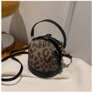 Detail of leopard print bucket bag with black leather trim and elegant gold hardware