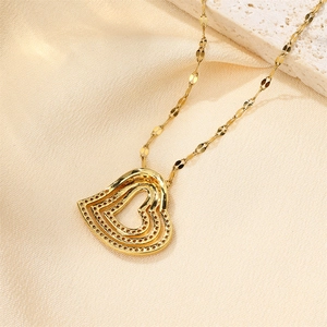 Detailed close-up of a triple-layered gold heart pendant necklace with shimmering zircons