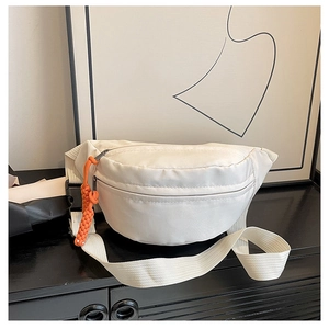 Close-up of white canvas chest bag featuring a contrasting orange zipper pull and wide strap