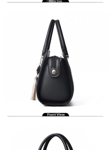 Detail view of black crocodile pattern tote bag featuring a tassel and gold hardware