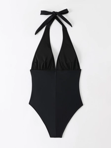 Close-up of black one-piece swimsuit with halter neck, deep V-neck and ruched details