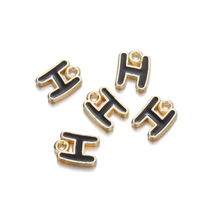 Detailed macro view of five gold-plated letter H charms with black enamel filling