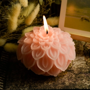 Pink lotus flower scented candle with burning wick and realistic multi-layer petal texture