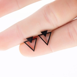 Minimalist double triangle black studs shown on fingertip for size perspective