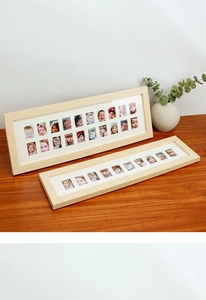 Detail of wooden multi-photo school growth frames with white matting on dark wood table