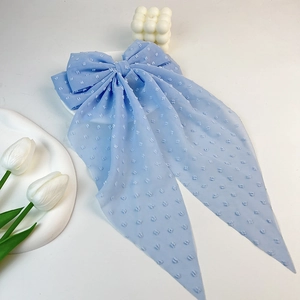 Detail of light blue Swiss dot chiffon hair bow clip with long ribbons on white tray