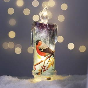 Festive LED pillar candle featuring winter bird prints on a snowy decorative surface