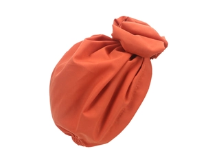 Detailed view of the pleated texture and floral knot on this orange turban headwear