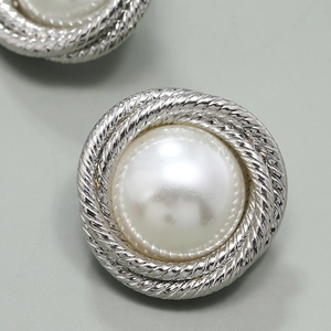 Macro shot of silver twisted rope frame earring with a lustrous white central pearl