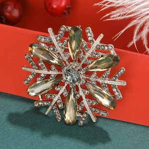 Macro detail of snowflake brooch with olive green crystals on a festive gift box