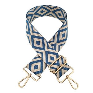 Detail of blue and beige geometric diamond pattern woven bag strap with gold metal hooks