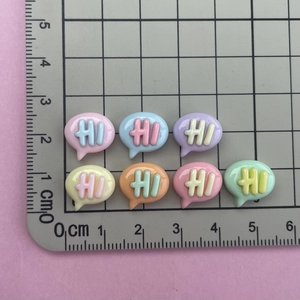 Macro detail of colorful resin bubble charms with HI letters for DIY craft projects