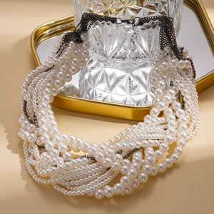 Macro detail of layered baroque imitation pearl necklace with rhinestone accents