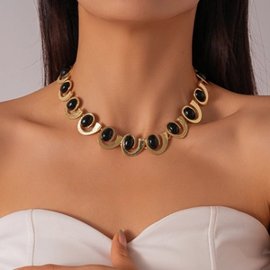 Vintage gold-plated U-link choker necklace with elegant oval black gemstones on a model
