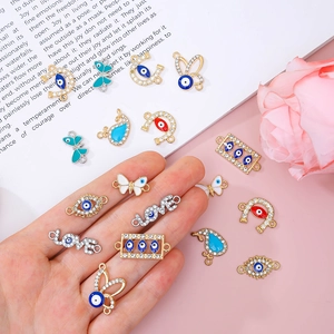 DIY jewelry charms including evil eye and butterfly designs with crystal rhinestones
