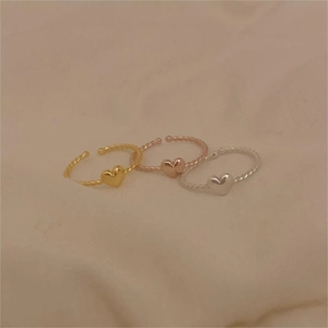 Detailed macro view of S925 silver heart rings with twisted rope bands in three colors