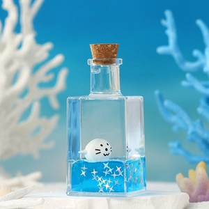 Marine theme drifting bottle with floating seal figure and blue liquid desktop ornament