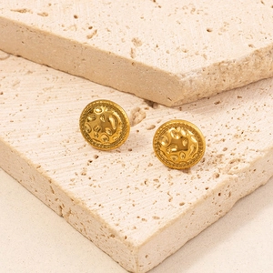 Detail of vintage round gold earrings with hammered texture and rope edge on stone
