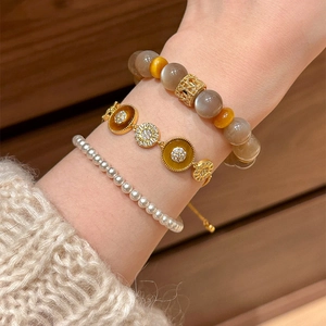 Ensemble de bracelets plaqués or 18k avec acétate et zircons sur le poignet d'un mannequin