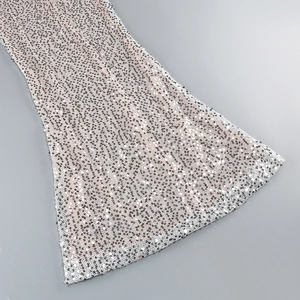 Detail of silver sequins on pink mesh fabric with a flared hem for evening dresses