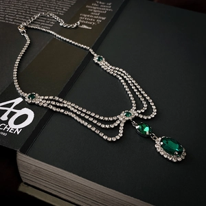 Detail of silver layered necklace with emerald green crystals and sparkling clear rhinestones