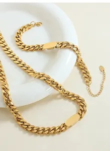 Gros plan détaillé d'un collier chaîne gourmette dorée avec pendentif ovale et fermoir homard