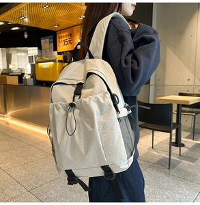 Detailansicht eines beigen wasserdichten Nylon-Rucksacks mit Kordelzug und Netztaschen