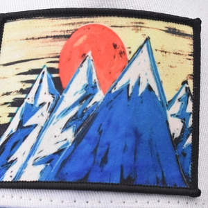 White trucker hat with mountain peak embroidery patch and breathable mesh panel back