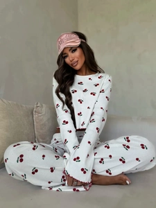 Close-up of red cherry print pajama set featuring flare sleeves and lettuce trim detailing