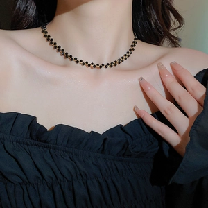 Detail der schwarz geflochtenen Perlen und Goldkette, getragen von einem eleganten Model