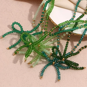 Green faceted crystal bead necklace with gold spacers in a stacked elegant display