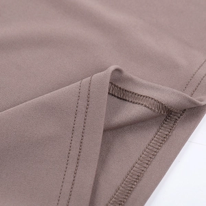 Close-up of professional hem rolling and sewing stitches on coffee brown knitted dress