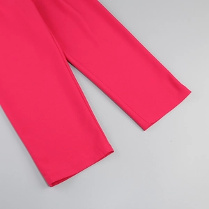 Close-up of rose red trousers hem showing neat stitching and premium fabric texture