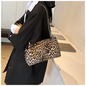 Fashionable leopard print shoulder bag with chain strap and metal T-clasp on model