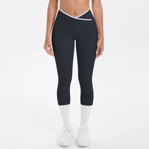 Détail du legging de yoga taille haute croisée avec bordure blanche et tissu noir mat