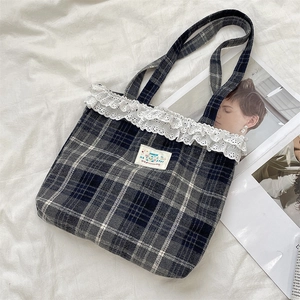 Detailed view of vintage plaid tote bag with delicate lace trim and Happy patch