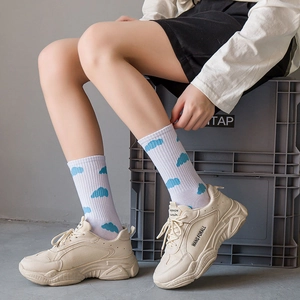 Beige chunky sneakers paired with white socks featuring cute blue cloud patterns