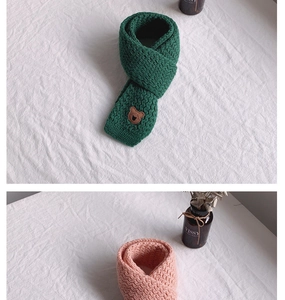 Dettaglio sciarpa in maglia per bambini con toppa a forma di orso verde e rosa