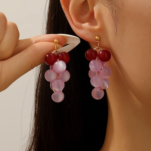 Detail of vintage grape-shaped earrings featuring purple and burgundy resin beads