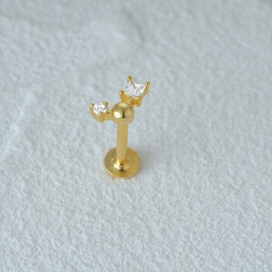 Detailed macro shot of golden flat back stud featuring round and square zircon stones