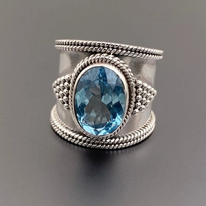 Anello vintage a fascia larga in argento con grande gemma blu ovale e dettagli a treccia