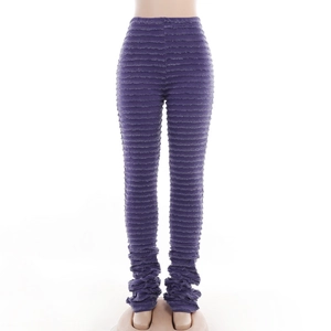 Détail du pantalon violet en maille avec texture plissée horizontale et effet empilé
