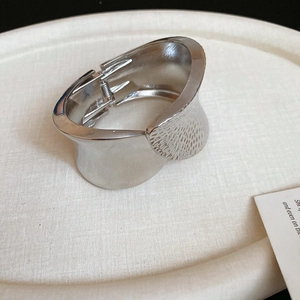 Detailed macro of silver irregular cuff bracelet featuring a mixed smooth and hammered texture