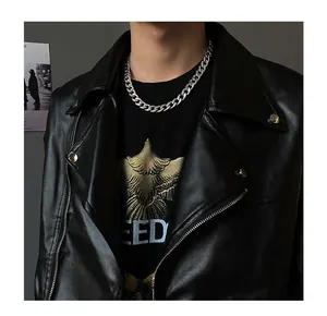 Gros plan d'une chaîne cubaine argentée portée avec une veste en cuir noir de style streetwear