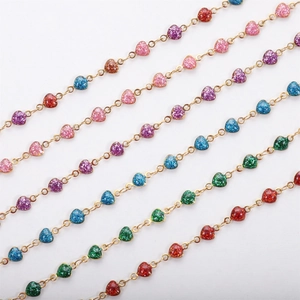Close-up of colorful glitter resin heart charms connected by 18k gold plated chains