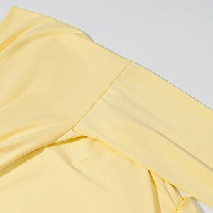 Detail view of the fine knit texture and shoulder seam on this pale yellow dress